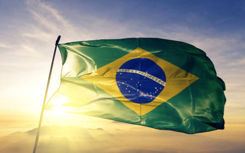 Brazil Brazilian flag on flagpole textile cloth fabric waving on the top sunrise mist fog